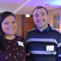 Two alumni smile for a photo together